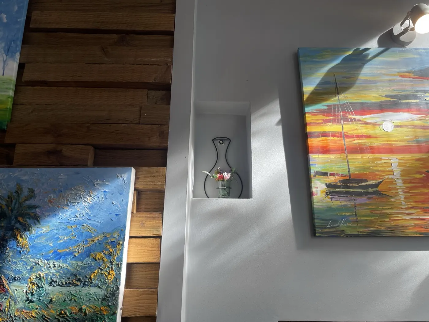 Paintings and a small vase on the wall